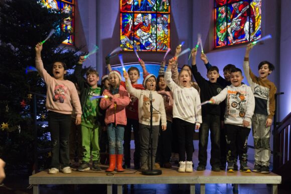 Kinder der 3A singen in der Kirche das Lied von den Lichterkindern.